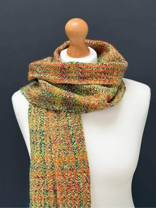 green and orange handwoven scarf on a model