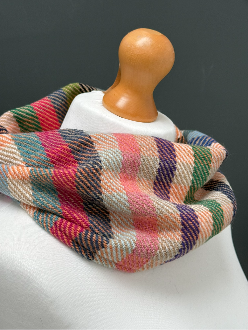 beige, blue, orange and green striped snood  scarf on a mannequin