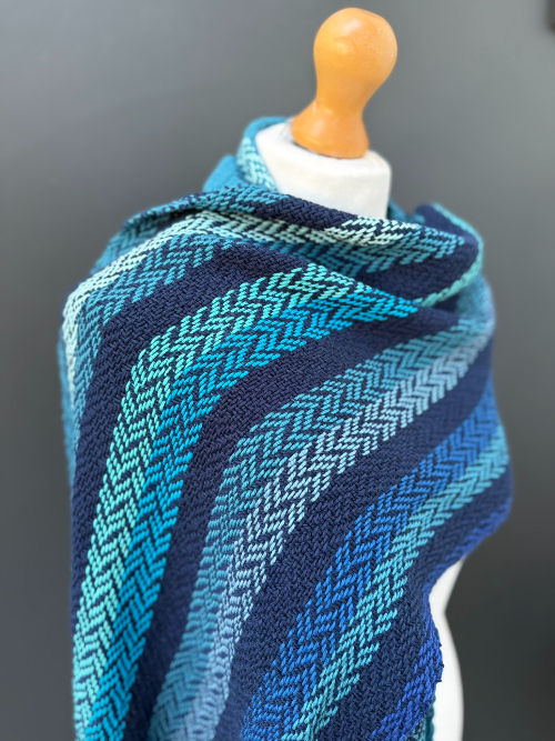 Thumbnail: blue and teal cotton scarf on a mannequin against a dark grey wall