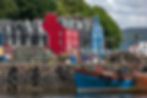 A photograph of Tobermory, Mull. Beautiful painted houses and a small boat.
