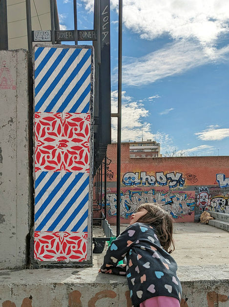 Full view of UNO's spray-painted paste-up installation on a Madrid street wall (2025).