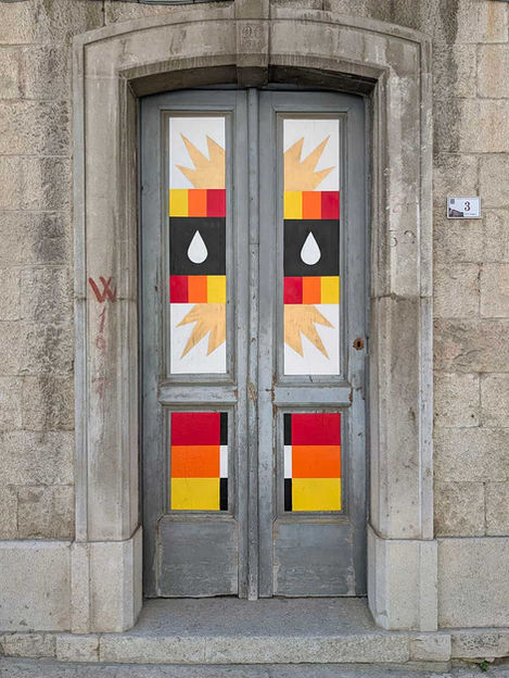 Full view of IMAGO GEMINA 86030, a spray paint intervention on a historic wooden door in Civitacampomarano, Italy.