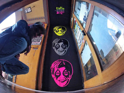 Spray paint intervention on black fabric within archway, fish-eye view. Repetitive Günter Icon stencils in neon colours. 2014