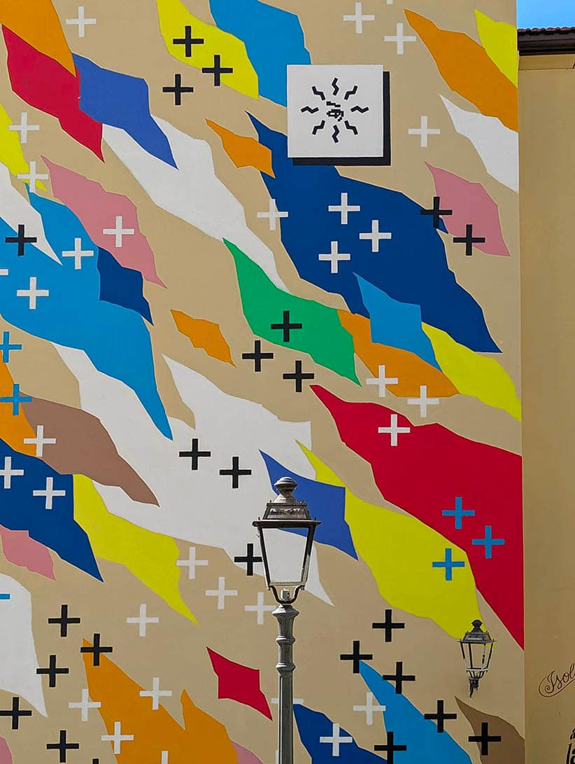UNO street art Salerno: detail of hand-painted geometric patterns and vintage street lamp.