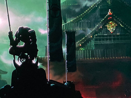 Predator holds a spear and kneels atop a temple with two sashimono and pagoda castle behind him.