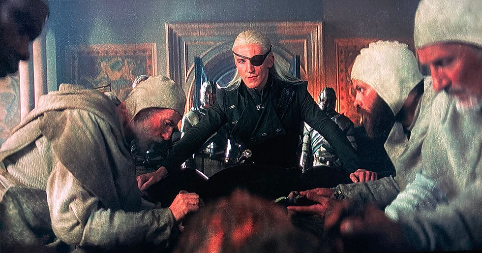 Aemond stands over his badly burned brother, as the maesters work on him.