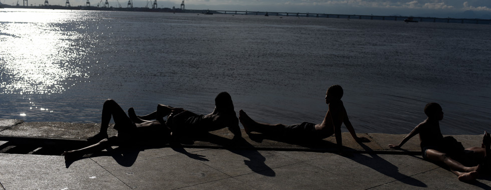 Crianças brincam e nadam na baia de Guanabara apesar da poluição