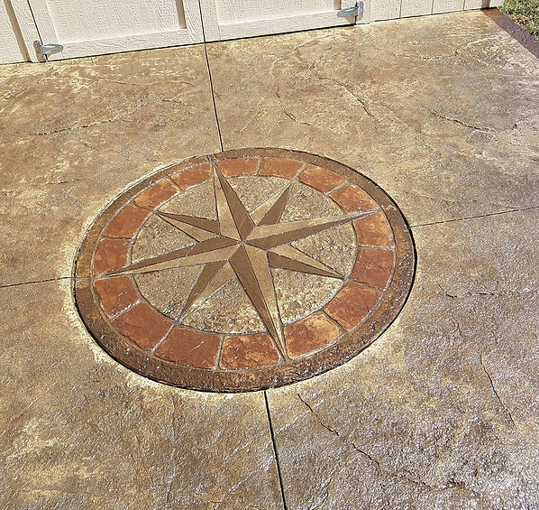 A celestial compass star in varying tones of brown stamped onto a concrete driveway by Garay Concrete at a Colorado home.