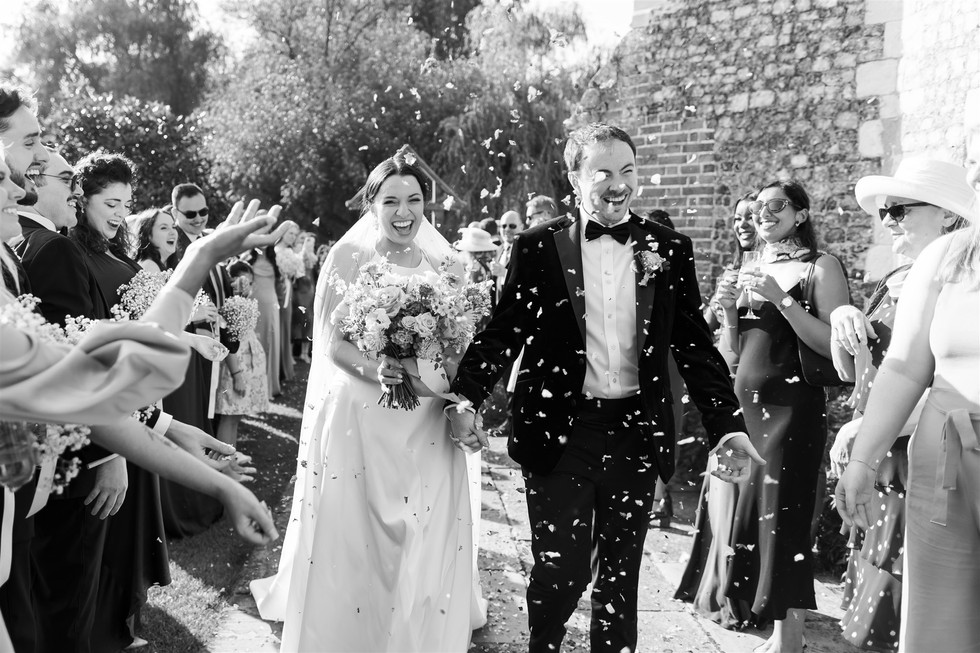 bride and groom laughing during confetti throw