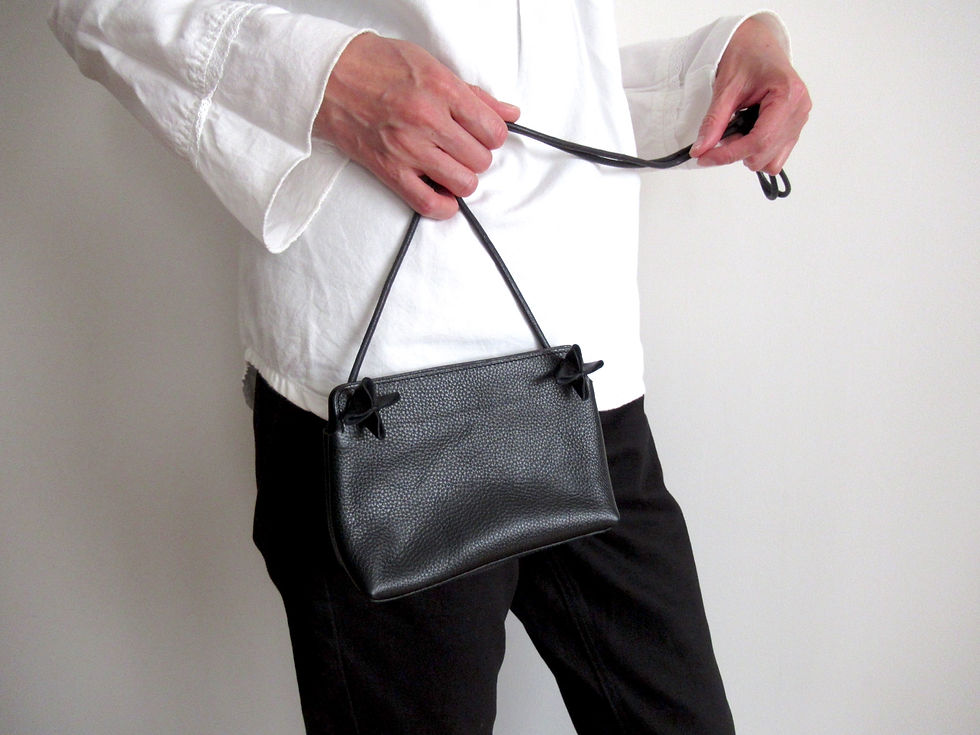 ミニショルダーバッグを前に持っている