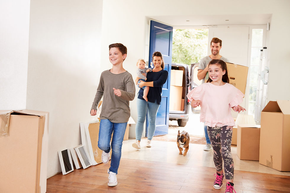 A young family with their bulldog unpacking boxes in their new home, showcasing a smooth and successful move made possible with full support from their mortgage broker.