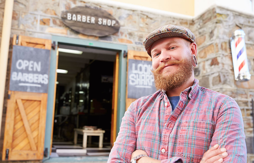 A self-employed barber stands confidently in front of his salon, celebrating his success in securing a mortgage with the help of an experienced broker.
