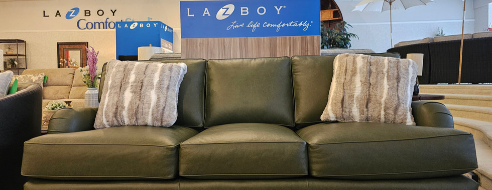The La-Z-Boy olive green leather sofa brings a rich, earthy warmth to any living space.
