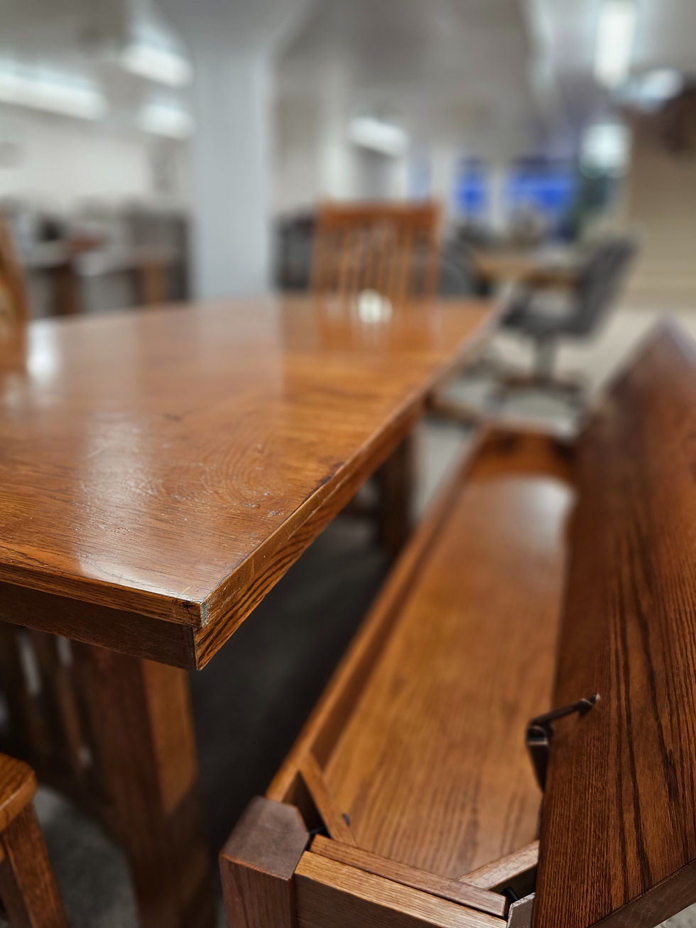 A close-up of a solid wood table and matching bench in the Werner Harmsen showroom, showing the smooth, consistent finish and rich grain of high-quality hardwood craftsmanship.
