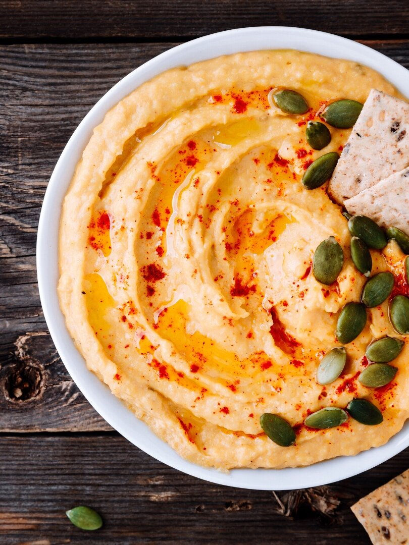 Plate with hummus and pumpkin seeds