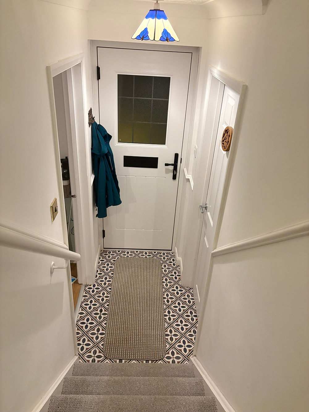 Home entryway with patterned floor tiles and white door