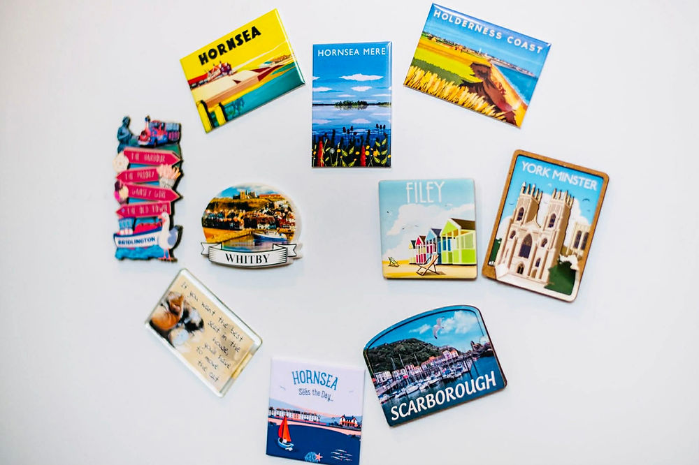 Collection of souvenir magnets from UK towns like York Minster, Whitby, Hornsea, and Scarborough.