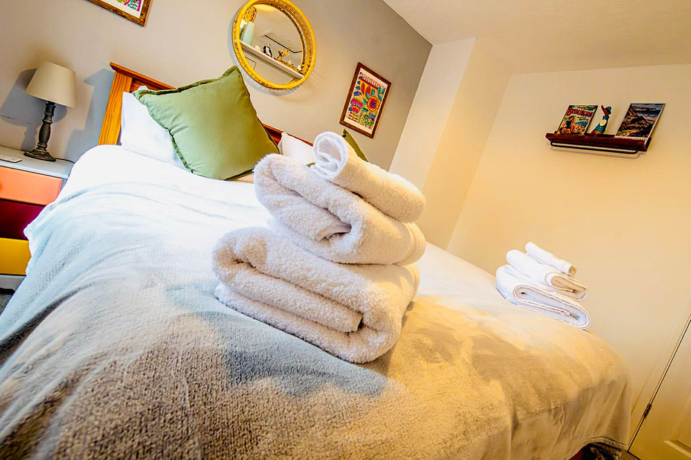 Bedroom with neatly folded white towels on a bed