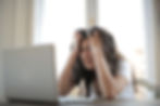 A girl looking frustrated at a laptop