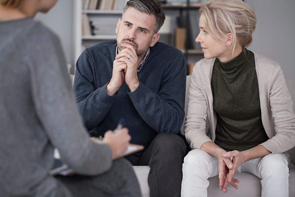 Divorcing couple sitting with mediator during negotiation session