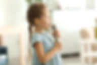 Cute little girl with microphone at home.jpg