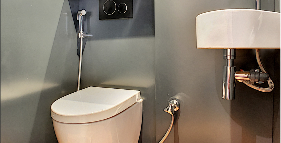 Toilettes alu gris anthracite avec des panneaux sur mesure afin d'éviter les joints. Cuvette blanche surélevé avec douchette - Lave-main blanc et au dessus armoire de toilette. Conçu par Casavog' agence d'architecture d'intérieur à Nice.