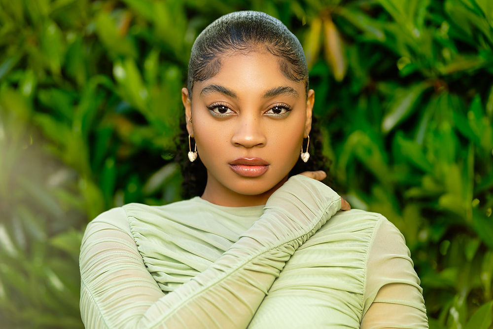 Woman in mint green dress posing in front of tree for an outdoor modeling portfolio shoot