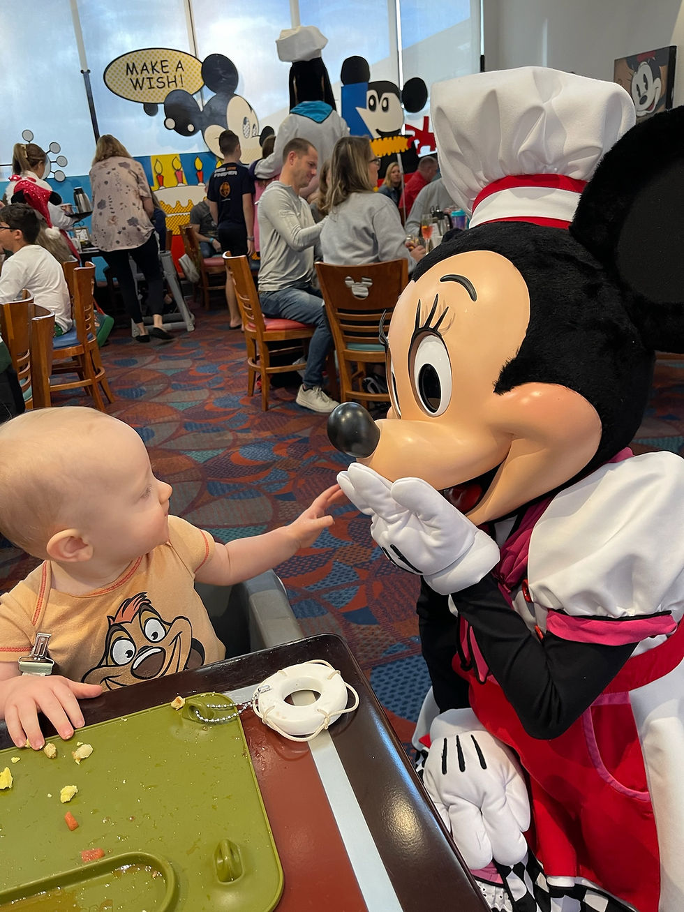 A baby saying hi to Minnie Mouse at Disney