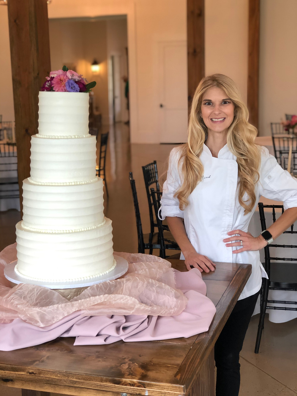 Baker with 4 Tier Large White Wedding Cake on Table