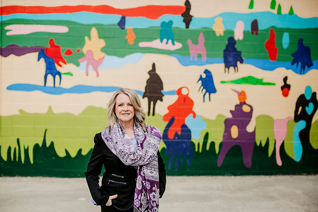susan chew life coach standing in front of mural