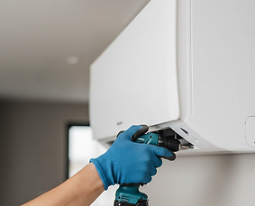 a hand reaching with a drill to install a minispplit system