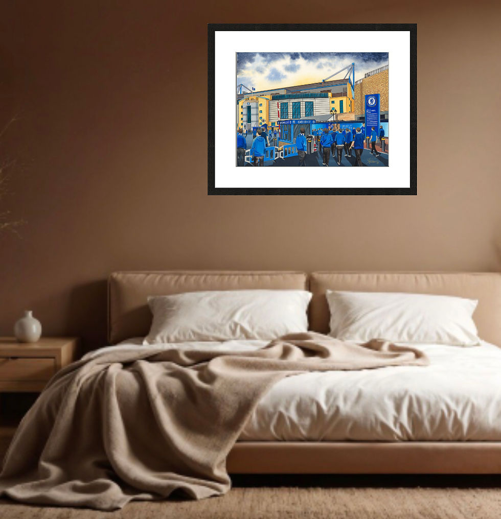 Cozy beige bedroom with an unmade bed and framed blue Chelsea FC stadium artwork on the wall.