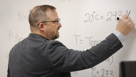 Daniel Matherly writing on whiteboard while teaching