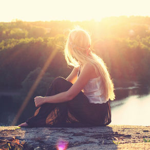 Teacher sitting calmly by a river at sunrise, practicing a mindful morning routine for teachers to reduce anxiety and begin the school day with calm.