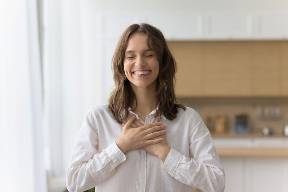 Mulher sorrindo e expressando gratidão, com as mãos sobre o coração em sinal de agradecimento.
