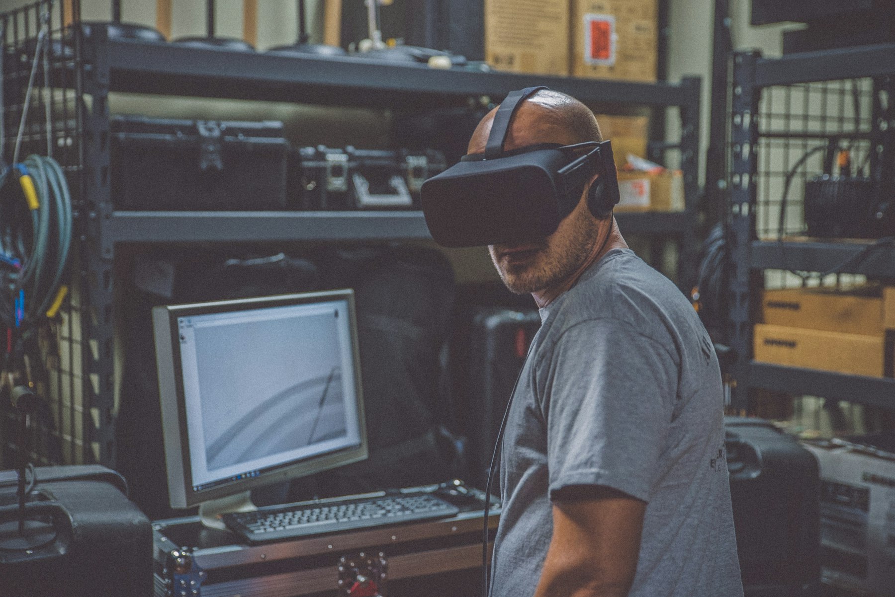 Woman testing a virtual reality headset beside a computer