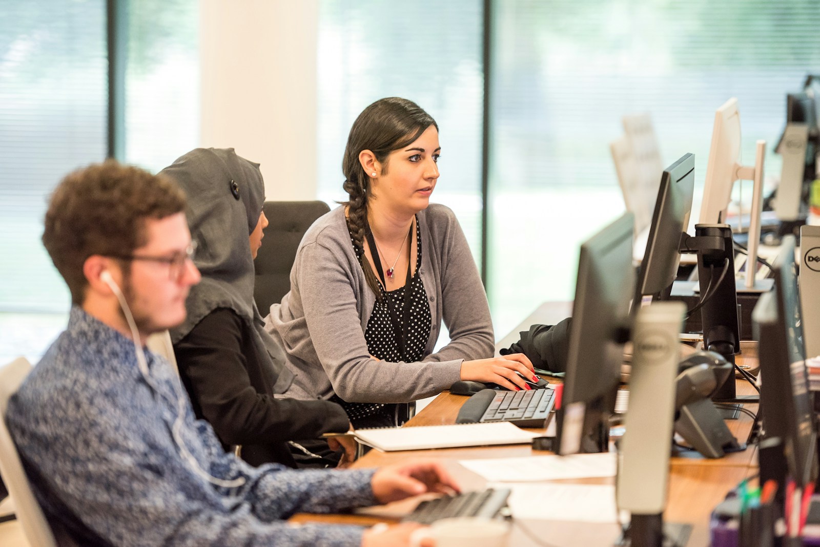 Customer support team using computers and headsets at work