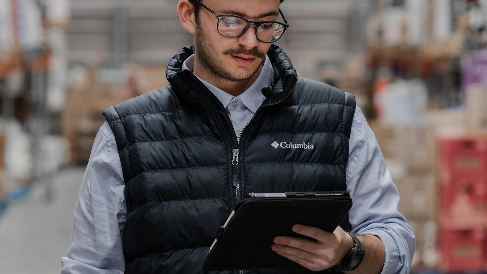 Industrial worker using a tablet in a warehouse suited to spatial computing guidance