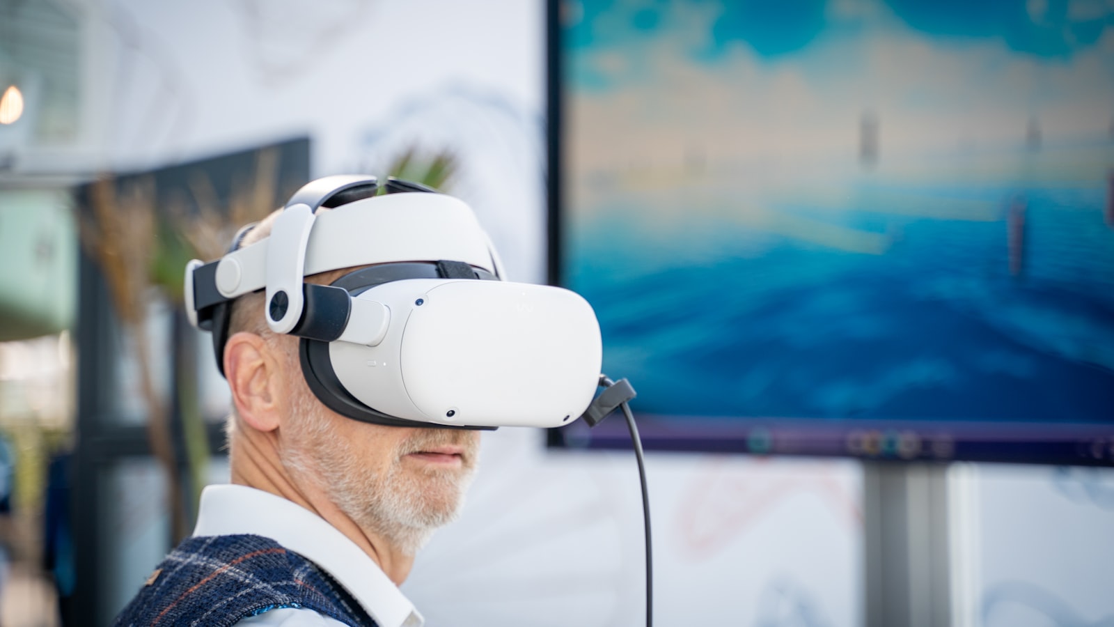 Developer wearing a virtual reality headset beside a laptop during spatial computing implementation