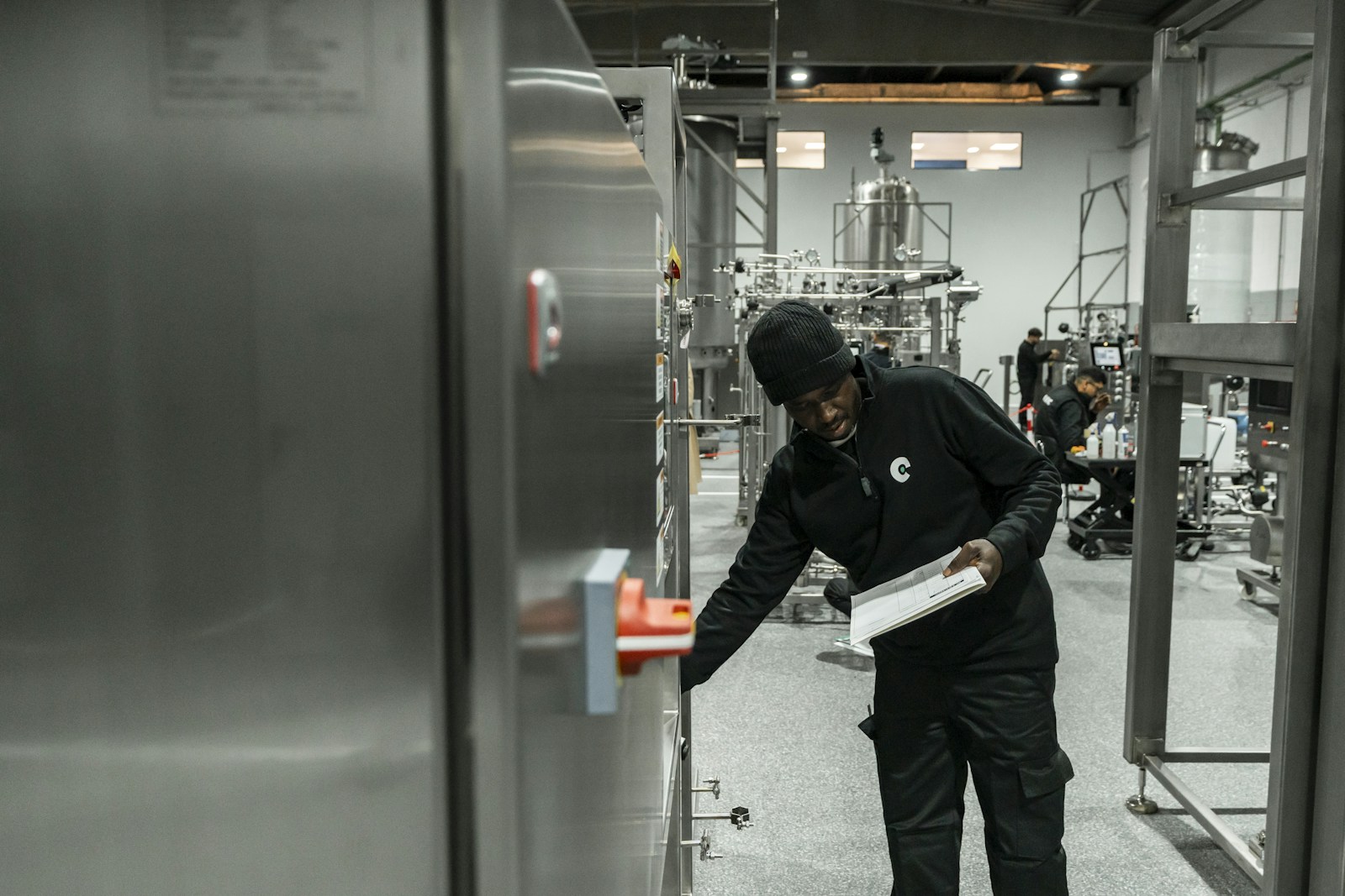 Technician inspecting industrial equipment with a checklist