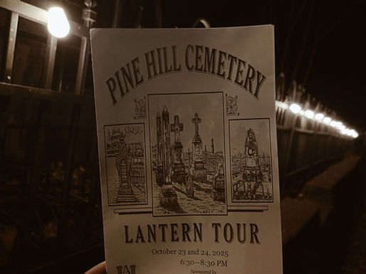 A hand holds a flier that reads "Pine Hill Cemetery Lantern Tour".
