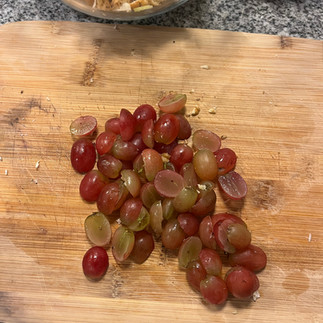 cut up grapes on a wooden cutting board