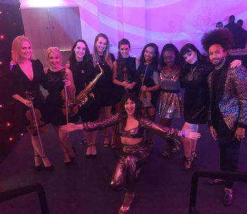 Band and singers pose for a photo at an event