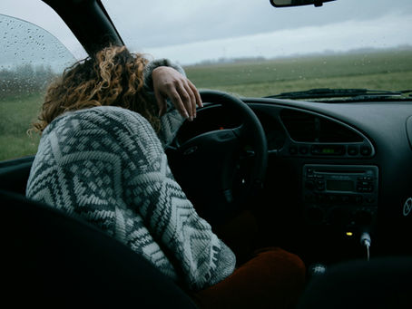 Exhausted woman sitting with head in hands. Representing the emotional drain of constantly complimenting a narcissist. Lynn Catalano, narcissistic abuse recovery expert shares how it affects you.
