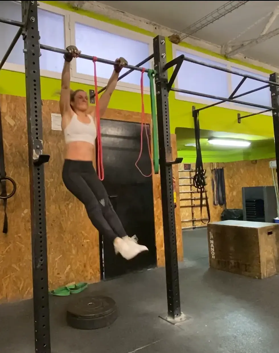 Jordana Sherman prepping to perform a bar muscle with the resistance bands present.