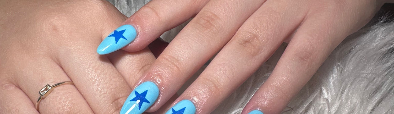 Light blue nail art with dark blue stars in River North.