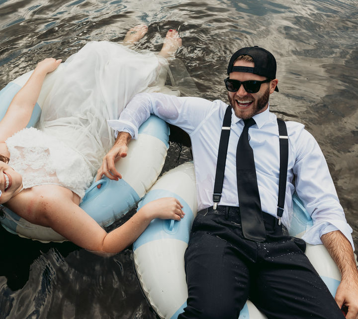 Bride and groom floating in a river on their wedding day in Cook Forest State Park