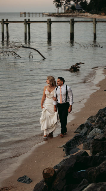 Bride and groom walking along the coast of the Chesapeake Bay in Maryland on their micro wedding day