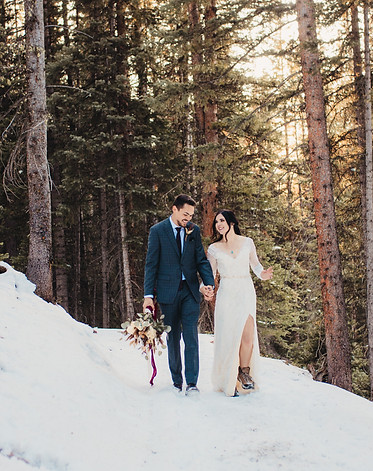 Elopement couple walking through the woods in the White River National Forest at Julia's Deck in Colorado