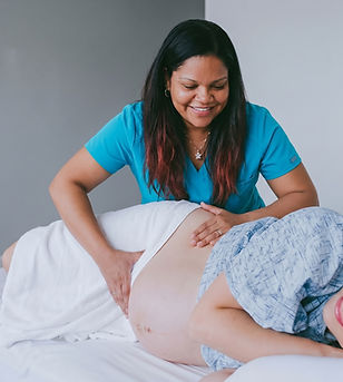 Midwife performing prenatal exam on a pregnant woman